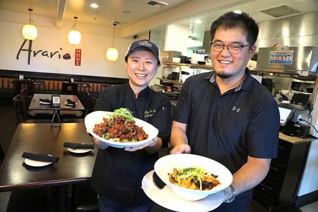 Arario owners presenting bowls of beef bulgogi in their restaurant